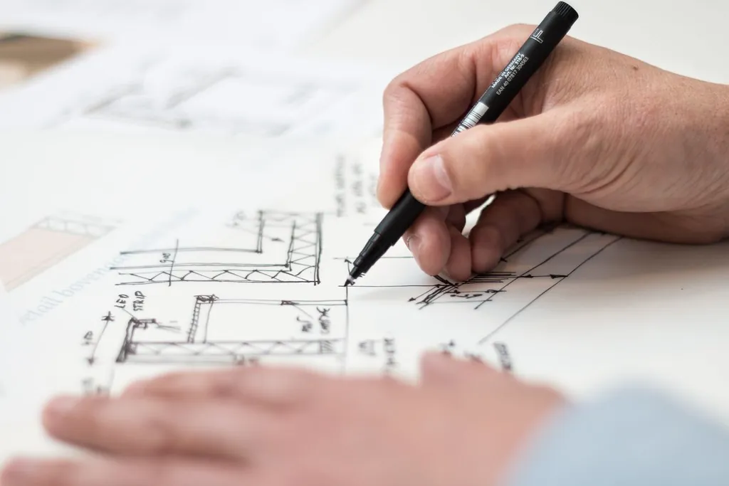Mano dibujando un detalle constructivo sobre un plano en el estudio